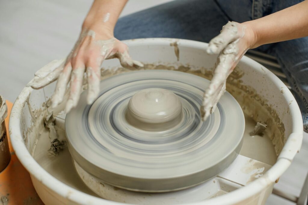 A potter shaping clay on a spinning wheel, symbolizing the continuous cycle of creation and transformation.